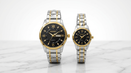 (Seiko) نوع موتور: کوارتز ژاپنی (باتریدار) جنس بدنه و بند: استیل ضد زنگ (Stainless Steel) ترکیب رنگ: دو رنگ (نقرهای - طلایی) رنگ صفحه: مشکی نشانگرهای زمان: ترکیب اعداد رومی و نگینهای کریستالی عقربهها: طلایی رنگ، دارای پوشش شبنما (Luminous) امکانات تقویم: مدل مردانه: نمایش روز و تاریخ (Day-Date) در موقعیت ساعت ۳ مدل زنانه: بدون تقویم طراحی قاب و بند: دور قاب (Bezel) و پیوندهای بند دارای برشهای هندسی (Faceted) جنس شیشه: کریستال معدنی (هاردلکس - مقاوم در برابر خط و خش روزمره) مقاومت در برابر آب: مقاوم در حد استفاده روزمره (Water Resistant)